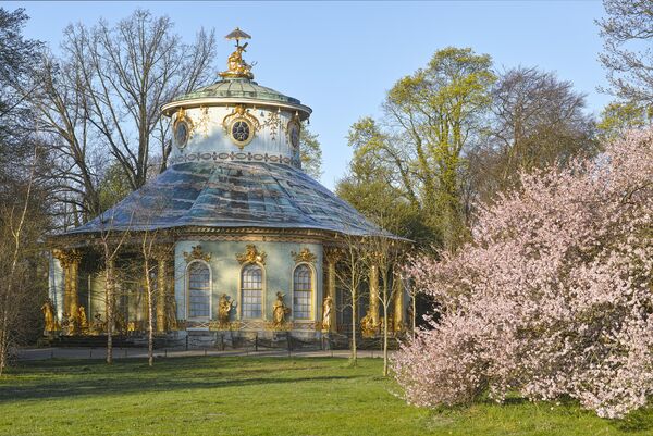 Das Chinesische Haus im Frühling, im Vordergrund blühende Sträucher 