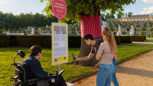 Besucher:innen in der Ausstellung „Re:Generation. Klimawandel im grünen Welterbe – und was wir tun können“